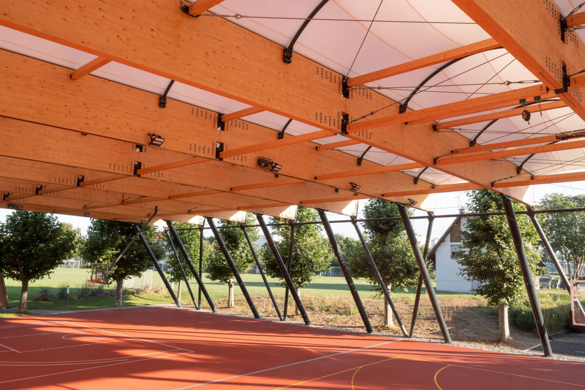 SMC2 a construit d'un préau sportif multisport dans le Haut-Rhin avec couverture en membrane textile et charpente bois avec poteaux acier.