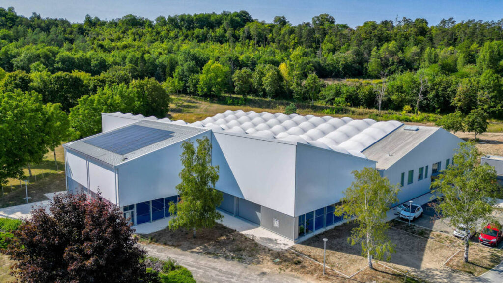 SMC2 a conçu et construit une halle sportive à Trélissac avec 4 courts de tennis et 2 de padel, alliant bois, acier et membrane textile.