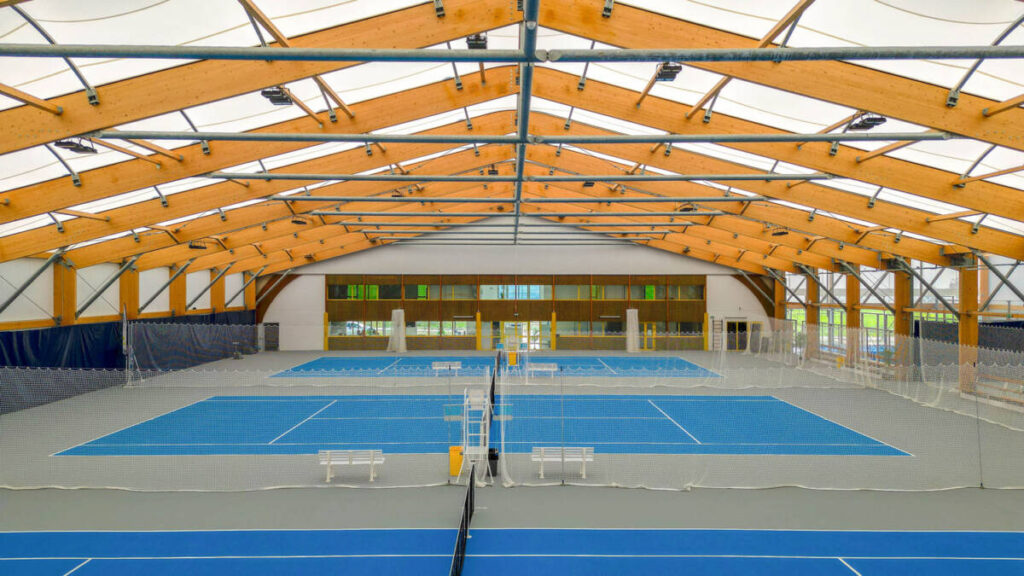 SMC2 a conçu et construit une halle sportive à Trélissac avec 4 courts de tennis et 2 de padel, alliant bois, acier et membrane textile.