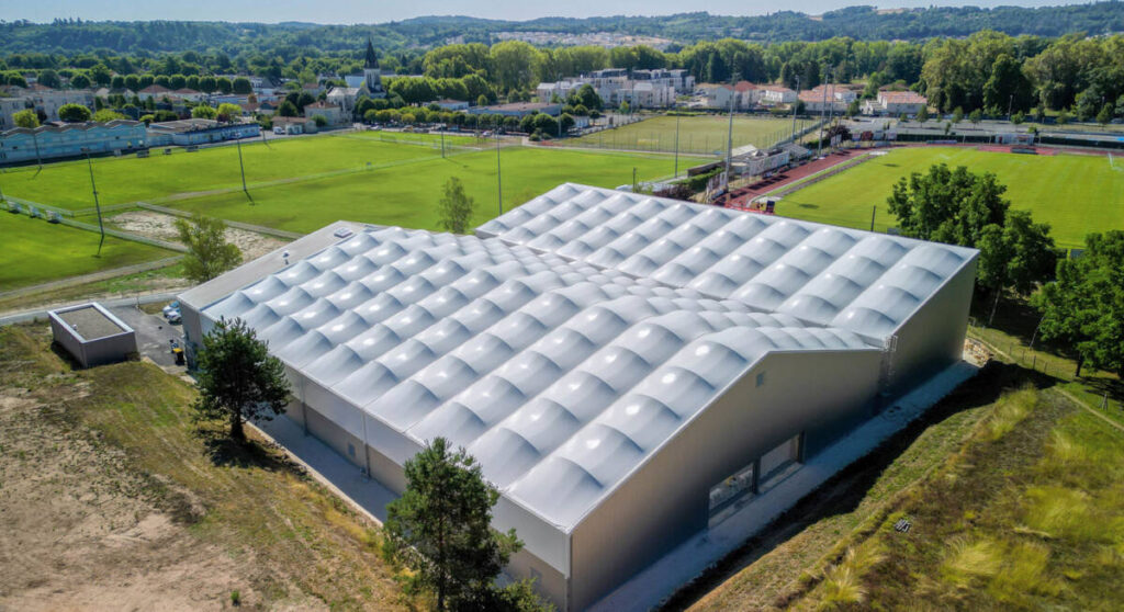 SMC2 a conçu et construit une halle sportive à Trélissac avec 4 courts de tennis et 2 de padel, alliant bois, acier et membrane textile.