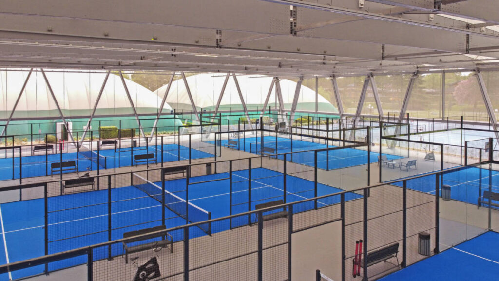 SMC2 a couvert 5 terrains de padel au club Les Pyramides avec une structure bois-acier grise et une membrane textile élégante et durable.