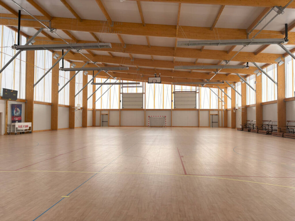 Construction d'un gymnase à Sénas en France. Un bâtiment durable en bois, dédié à la pratique du basket et du handball.