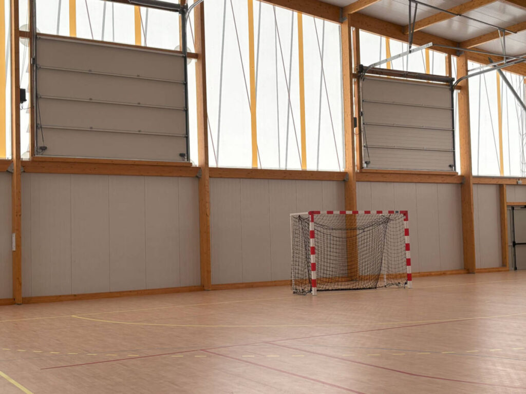 Construction d'un gymnase à Sénas en France. Un bâtiment durable en bois, dédié à la pratique du basket et du handball.