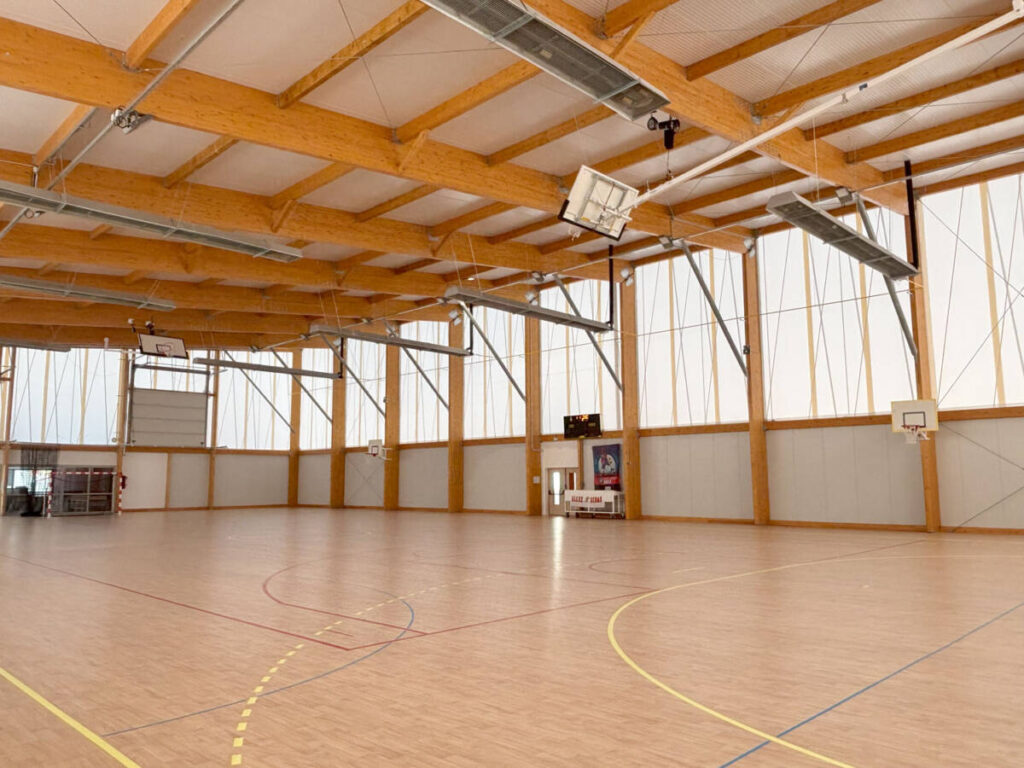Construction d'un gymnase à Sénas en France. Un bâtiment durable en bois, dédié à la pratique du basket et du handball.