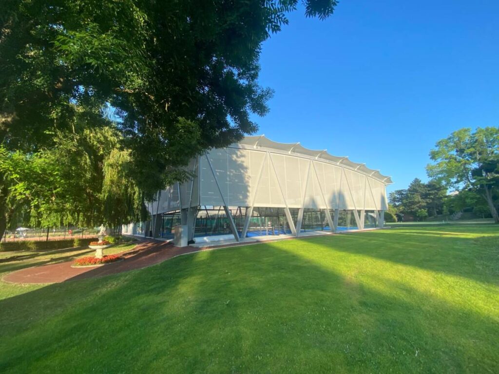 SMC2 a couvert 5 terrains de padel au club Les Pyramides avec une structure bois-acier grise et une membrane textile élégante et durable.