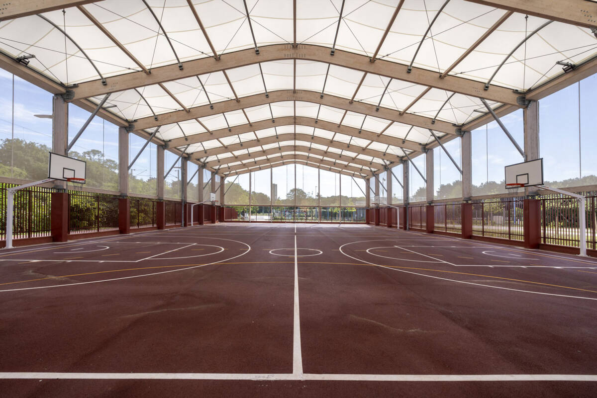 Construction d’un préosport de 2 000 m² au collège de Bobigny : structure bois-acier, couverture textile, façades micro-perforées et clôtures basses.