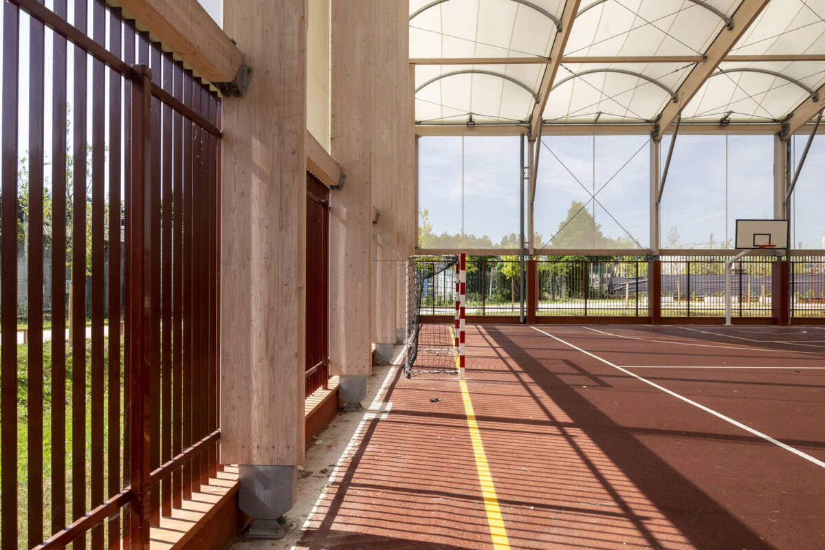 Construction d’un préosport de 2 000 m² au collège de Bobigny : structure bois-acier, couverture textile, façades micro-perforées et clôtures basses.
