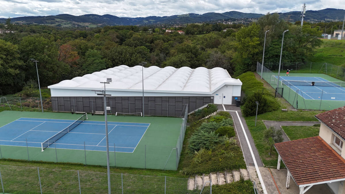 Construction d’un tennis couvert de 1400 m² : charpente bois lamellé-collé, membrane textile et sol sportif performant.