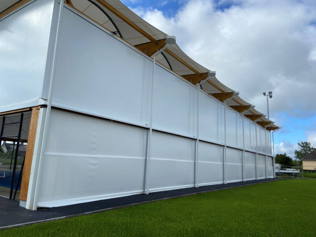 Découvrez le nouveau préau multisport de 908 m² à Quettreville-sur-Sienne, alliant membrane textile, charpente mixte et équipements modernes.