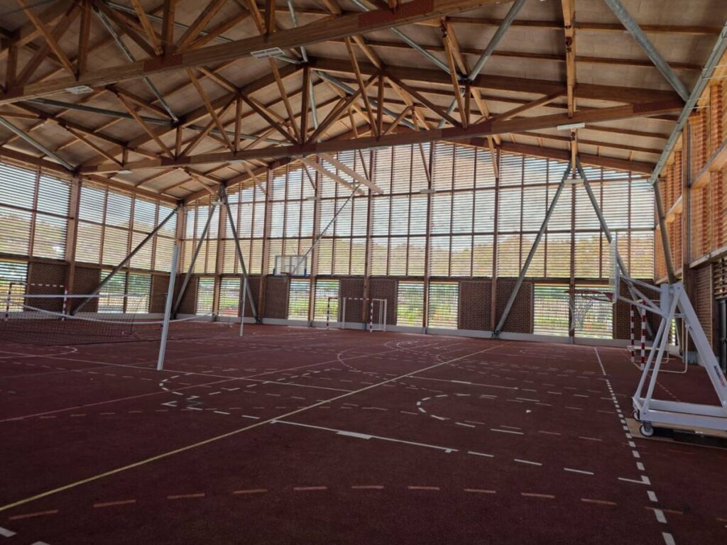 Complexe sportif à Mayotte : gymnase et salles spécialisées pour la jeunesse mahoraise permettant la pratique toute l’année.